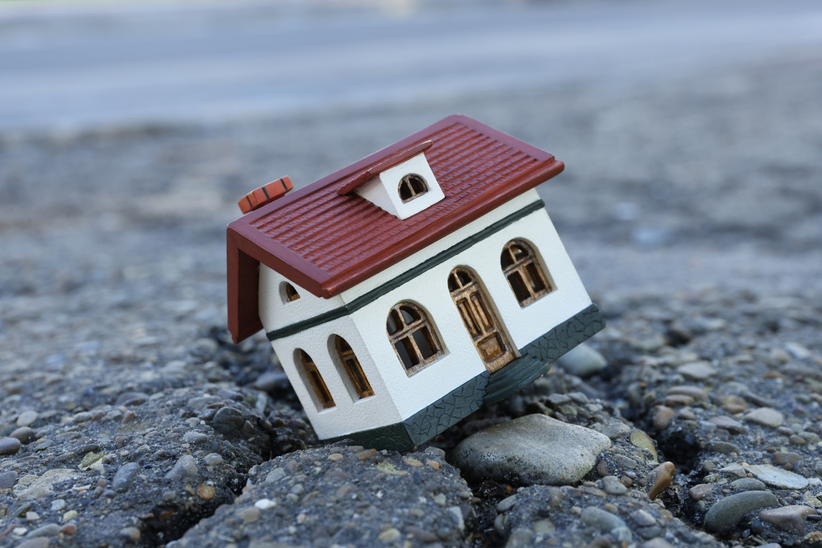 House Model in Cracked Asphalt. Earthquake Disaster