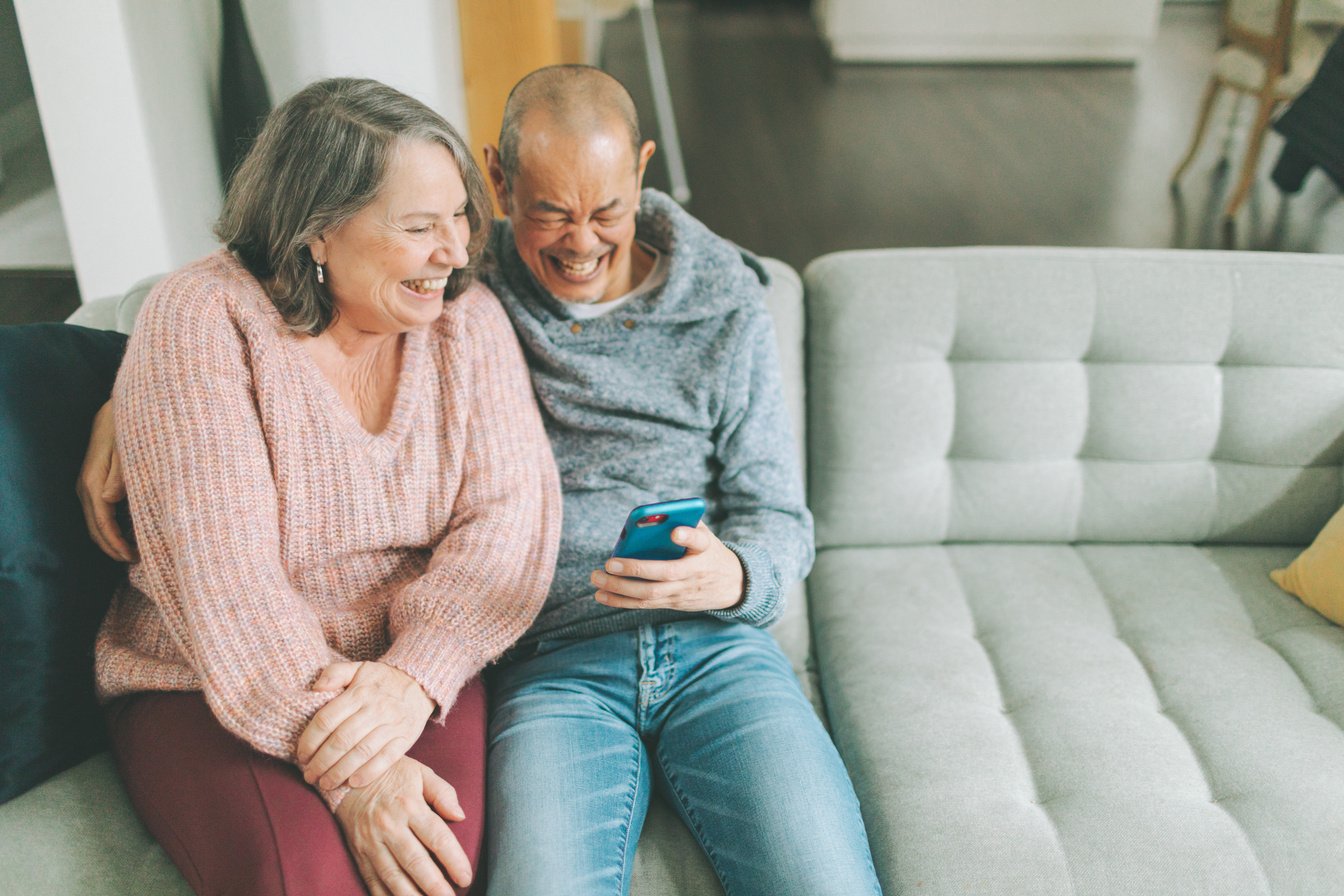 Elderly Couple Laughing While Looking at a Smartphone